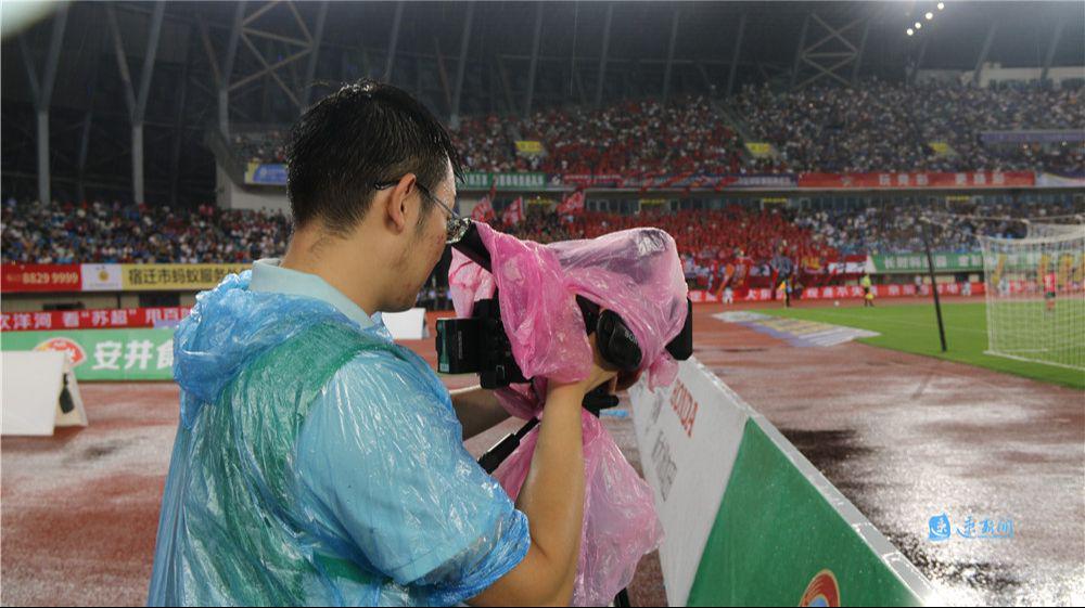 星空体育平台-主场内外看“苏超”·热力直击丨雨中“护枪人”：幕后记者用雨衣裹住设备坚持“战斗”